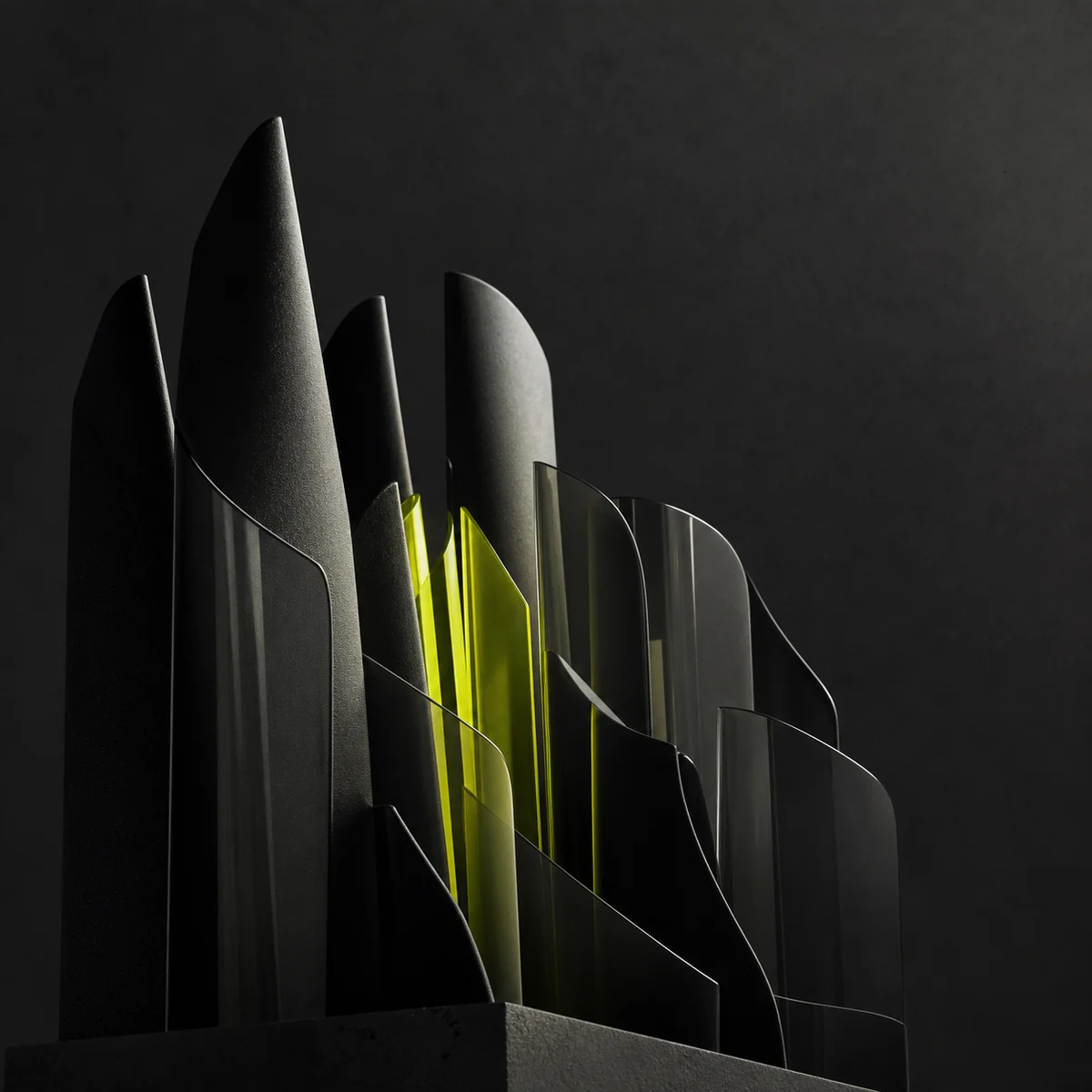 A group of sculptural black forms coordinated around a green core
